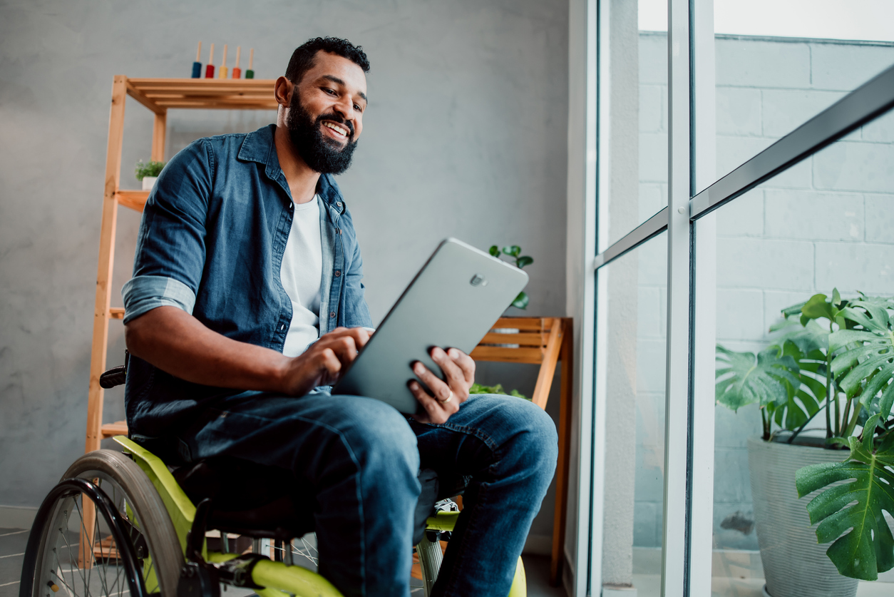 Homem em uma cadeira de rodas usando um tablet