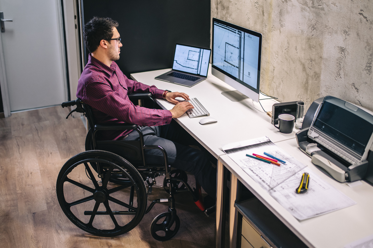 Arquiteto em cadeira de rodas, trabalhando em seu escritório.
